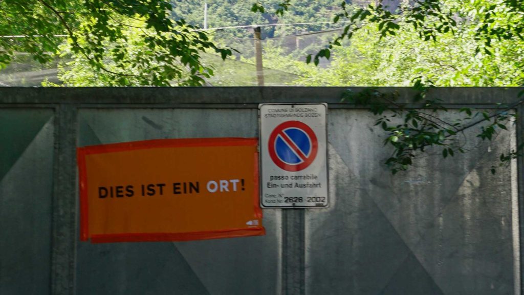 "Dies ist ein Ort!"-Poster on the gate of the area